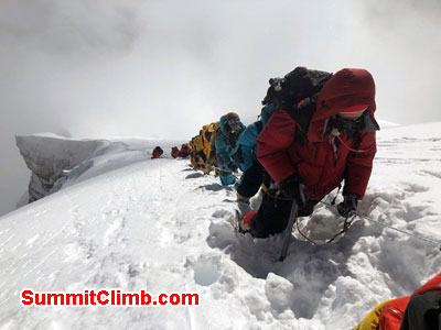 Waiting around 100m below the summit on the ridge for the final ropes to be secured